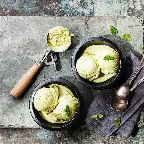 Eis Grüner Tee mit Minzblättern und Löffel für Eis auf Stein Schiefer Hintergrund