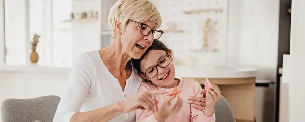 Großmutter und Enkelin spielen am Tisch