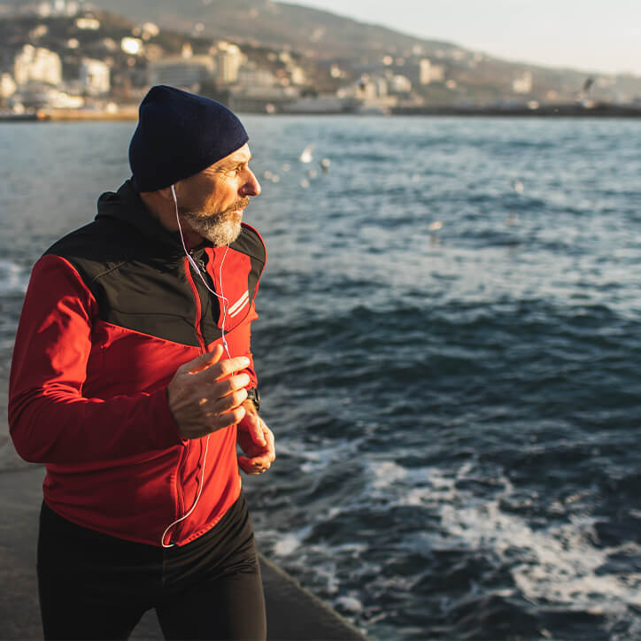 Älterer Mann joggt am Meer