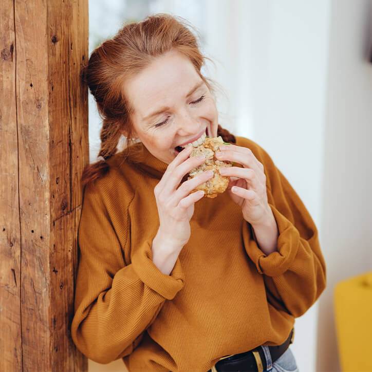 Frau beißt in Brötchen