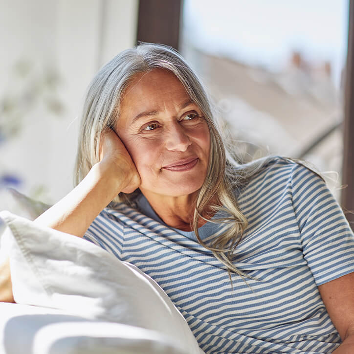 Frau mit grauen Haaren auf Sofa