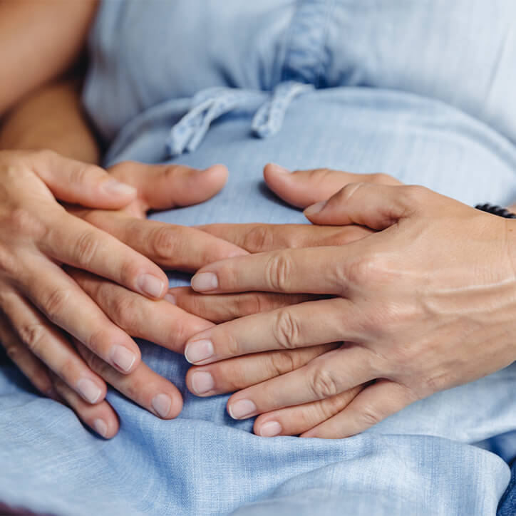 Nahaufnahme Bauch einer Schwangeren mit Händen Partner