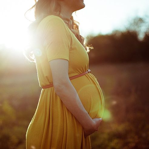 Schwangere steht in der Sonne