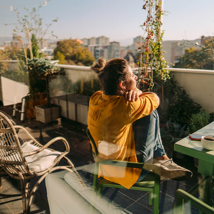 Frau genießt Sonne auf Balkon